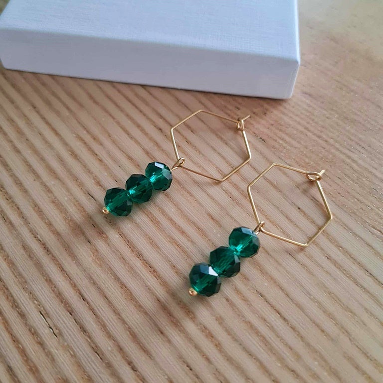 Kristallihiotut smaragdilasihelmet kulmikkaissa korvisrenkaissa.