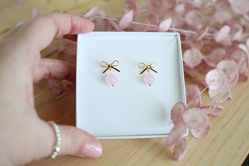 Kaunis rusetti ja luonnonkivihelmi muodostavat hurmaavan korvakorukokonaisuuden.